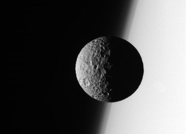 Mimas en arrière-plan de Saturne, image de la sonde Cassini.