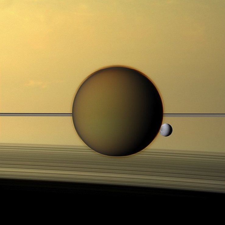 Titan, satellite de Saturne, à l'arrière-plan de la planète